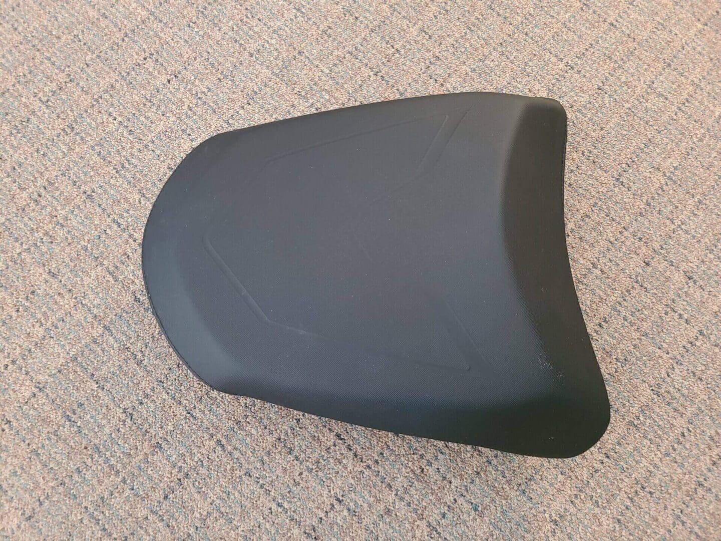 A small black color seat kept on the ground